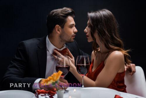 Elegant couple sharing an intimate moment over wine, showcasing the charm of exploring Kensington’s cultural scene with a dirty talk escort.